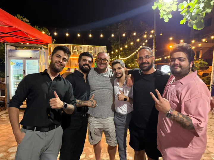 Friends gathered in front of the Habibi bar at night